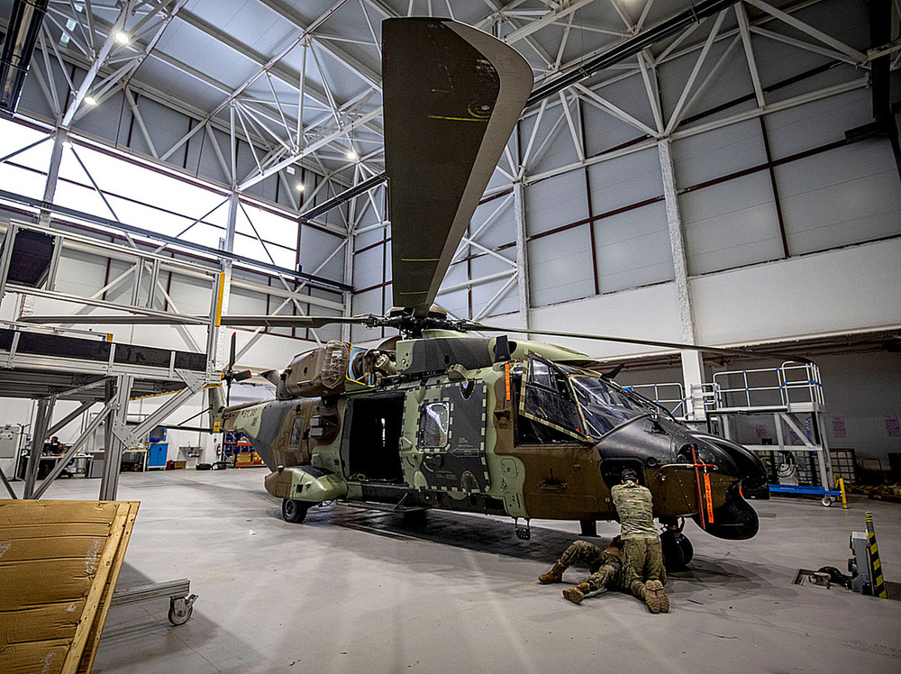 La revisión y mantenimiento de los helicópteros es constante; en la imagen dos mecánicos revisan un aparato en el hangar más moderno. 