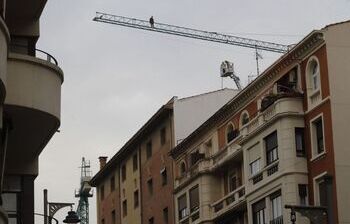 Los bomberos tratan de hacer bajar a un hombre de una grúa